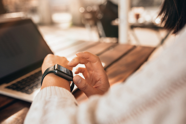 Young woman using smartwatch at a cafe