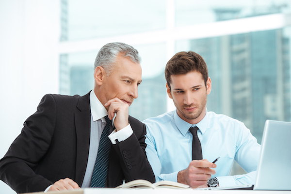 Aged and young businessmen having meeting