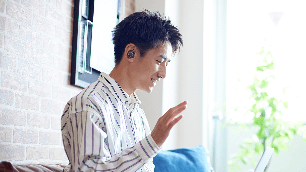 パソコンに向かって笑顔で挨拶をする男性
