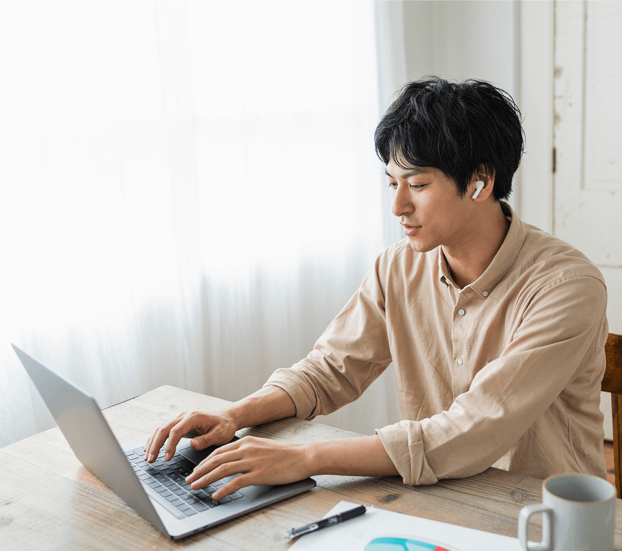 イヤホンを装着してパソコンに向かう男性