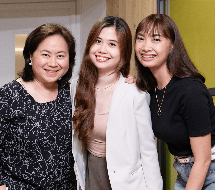 笑顔で肩を寄せ合う3人の女性講師