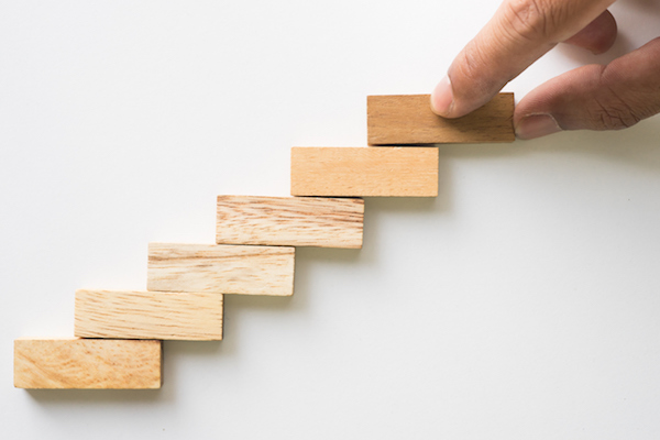 Hand aranging wood block stacking as step stair. Business concept for growth success process.